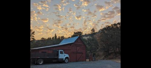 a truck parked in front of a red barn at Cozy Cabin, near Mosier and Hood River in Mosier