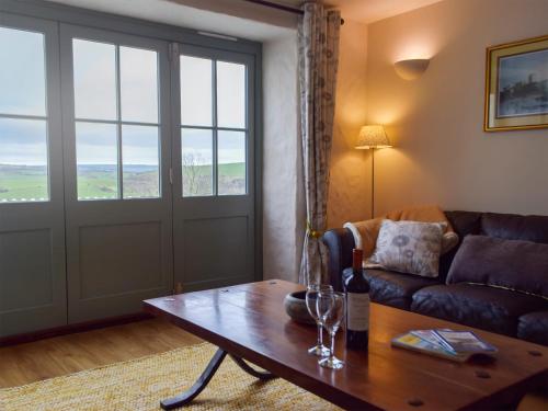 Una sala de estar con un sofá y una mesa de madera. en West Barn - Uk31850, en Trecwn