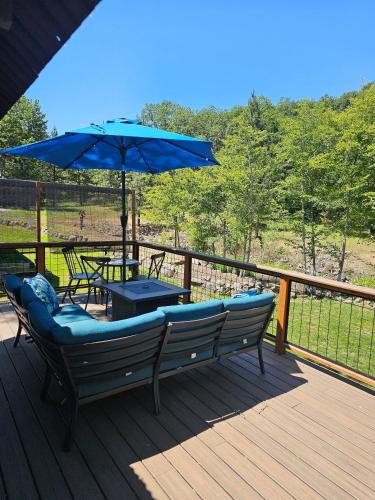 a deck with a bench and a table with an umbrella at Cozy Cabin, near Mosier and Hood River in Mosier