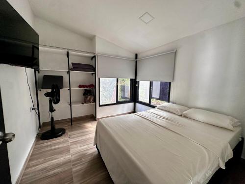 a bedroom with a large white bed and a window at Cabaña Familiar Rio Piscina Descanso Naturaleza 2habitaciones 5 personas in Santa Fe de Antioquia