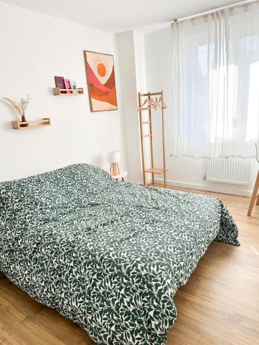 une chambre avec un lit avec une couverture verte dans l'établissement Maison Dune - mer & douceur de vivre à Plouha, à Plouha