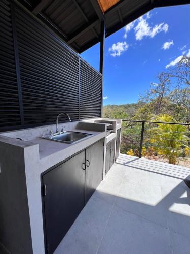 a kitchen with a sink and a balcony with a view at Guanacaste Marbella luxury home with a private pool in Santa Cruz