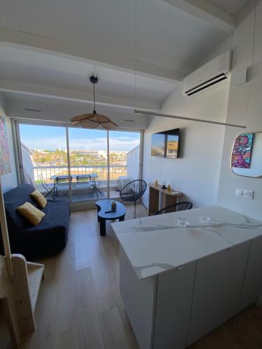 une cuisine et un salon avec un canapé et une table dans l'établissement Village naturiste Appart B Port Soleil, au Cap d'Agde