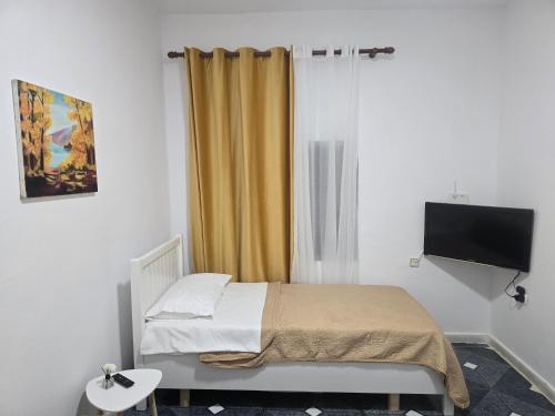 a small bedroom with a bed and a television at Eva & Resul apartments in Ilias