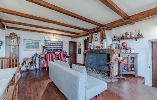 a living room with a fireplace and wooden ceilings at Nice Home In Fraz, Alpicella, Varaz in Il Pero