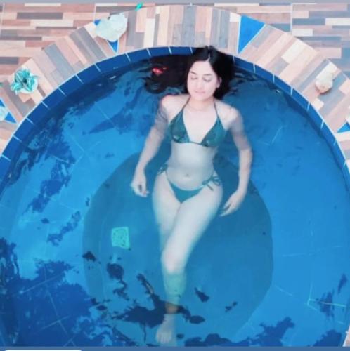 a woman in a swimsuit in a swimming pool at Chalés do AVOHAY, lindo chalé com privativo ofurô aquecido,apenas 2 minutos da Vila de São Jorge in Sao Jorge