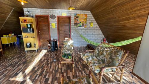 a living room with a couch and a hammock at Chalés do AVOHAY, lindo chalé com privativo ofurô aquecido,apenas 2 minutos da Vila de São Jorge in Sao Jorge