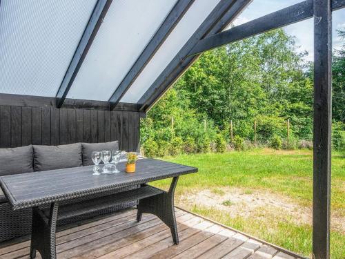 a picnic table on a deck with a view of a field at 5 person holiday home in Silkeborg in Silkeborg
