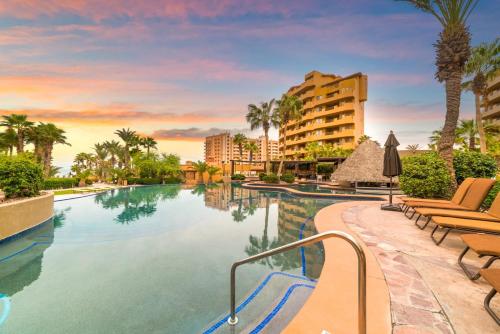 a pool at a resort with chairs and palm trees at Bella Sirena 2BR 2BA 1st FL Spacious Patio B104 in La Choya