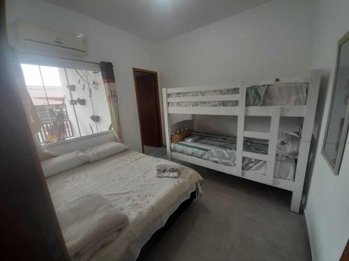 a small bedroom with a bed and a window at Flat novo 103 a pé da Prainha Mambucaba Paraty RJ in Paraty