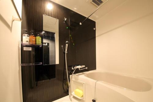 a bathroom with a bath tub and a shower at S-rea TOKYO in Tokyo