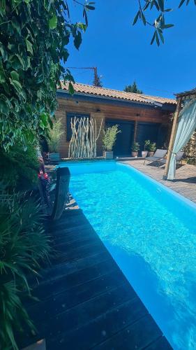 une piscine bleue devant une maison dans l'établissement Charmante maison de ville en pierre avec piscine, à Eysines