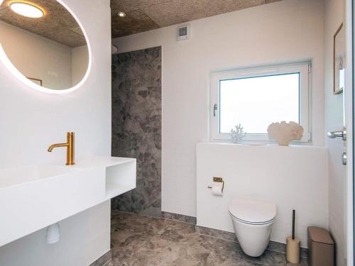 a bathroom with a toilet and a sink and a window at 5 star holiday home in Glesborg in Glesborg