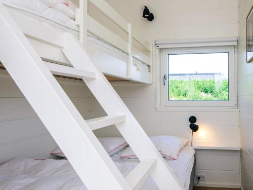 a small bedroom with white bunk beds and a window at 5 star holiday home in Glesborg in Glesborg