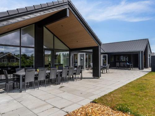 a patio with a bunch of chairs and tables at 5 star holiday home in Nørre Nebel in Nørre Nebel