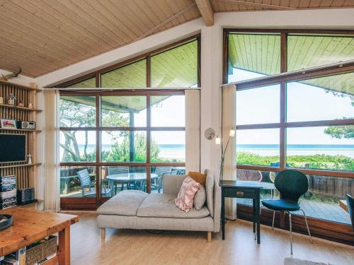 a living room with a couch and a table and windows at 4 person holiday home in Glesborg in Glesborg
