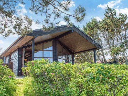 a small house with a wooden roof and windows at 4 person holiday home in Glesborg in Glesborg