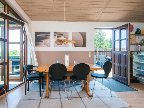 a dining room with a wooden table and chairs at 4 person holiday home in Glesborg in Glesborg