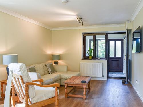 a living room with a couch and a table at Swallow Cottage in Gowerton
