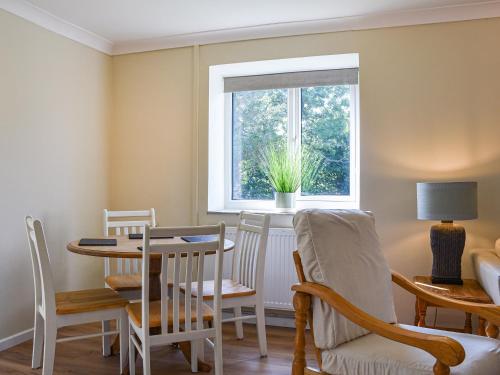 a dining room with a table and chairs and a window at Swallow Cottage in Gowerton