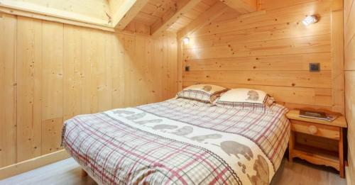 a bedroom with a bed in a wooden cabin at Gite Les Tarines 1 in Beaufort
