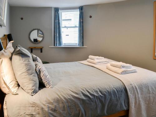 a bedroom with a bed with towels on it at The Old Toll House in Portpatrick