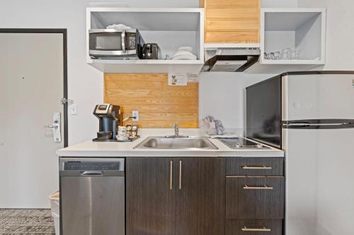 a small kitchen with a sink and a refrigerator at River Inn at Seaside in Seaside