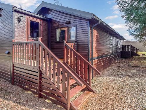 Una rampa de madera que conduce a una casa de madera. en 27 Aviemore Holiday Park, en Aviemore