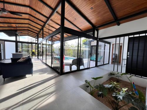 a living room with glass walls and a ceiling at Guanacaste Marbella luxury home with a private pool in Santa Cruz