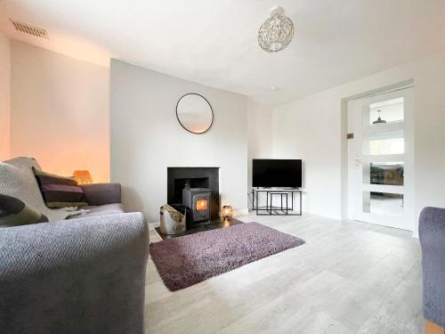 a living room with a couch and a fireplace at Academy Street Cottage in Tain
