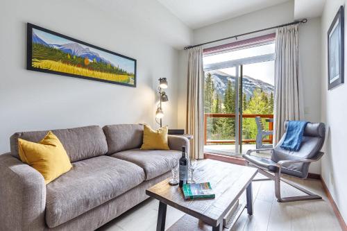 a living room with a couch and a table at Mountain Luxe in Canmore