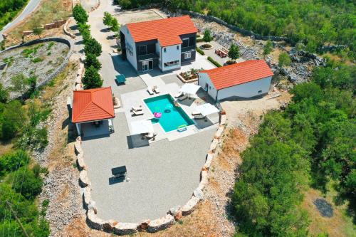 an aerial view of a house with a swimming pool at Vila Agape with a pool, football and tennis court in Lovreć