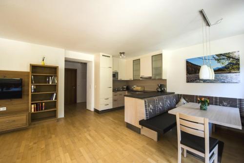 eine Küche und ein Wohnzimmer mit einem Tisch und einem Esszimmer in der Unterkunft Ferienhaus am Rohntalbach in Hinterriss