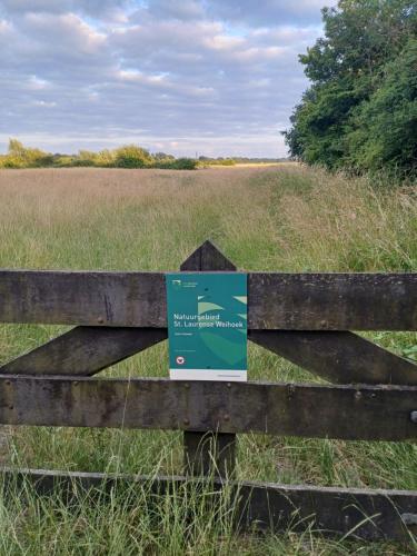 a sign on a fence in a field at Zeeuws Huusje in Middelburg