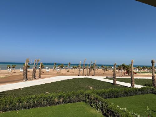 a view of a beach with palm trees and a sidewalk at Boutique Residence Mangroovy-Lemon Spaces Gouna in Hurghada