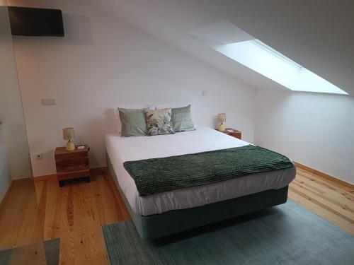 a bedroom with a large bed with a window at Fragas do Cabril Eco & Wellness Lodge in Lousã