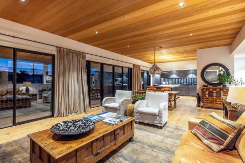 a living room with a wooden ceiling at Moa Luxe - Stay Waiheke in Waiheke Island