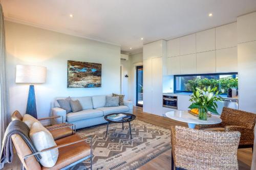 a living room with a couch and a table at Moa Luxe - Stay Waiheke in Waiheke Island