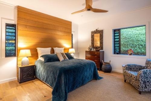 a bedroom with a large bed with a wooden headboard at Moa Luxe - Stay Waiheke in Waiheke Island