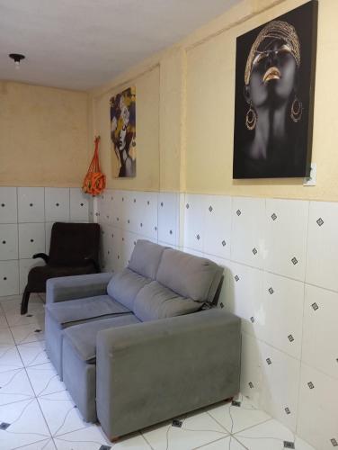 a living room with a blue couch and a chair at Residencial Lima - Quarto 06 in São Luís
