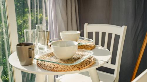 a white table with plates and cups on it at Casa Ejecutiva Boquete in Boquete