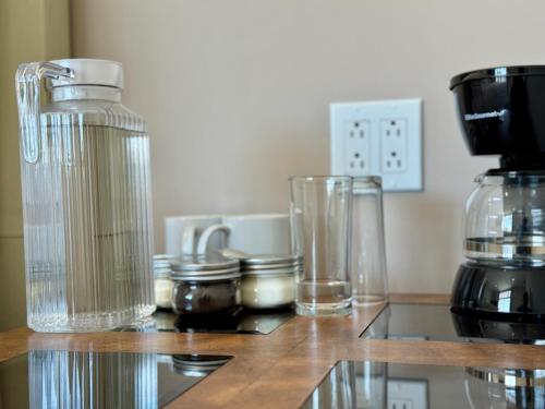 a counter with glasses and a coffee maker on it at Suites Lassa in Ensenada