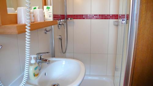 ein Bad mit einem Waschbecken und einer Dusche in der Unterkunft Gästehaus Kaiser in Menzenschwand