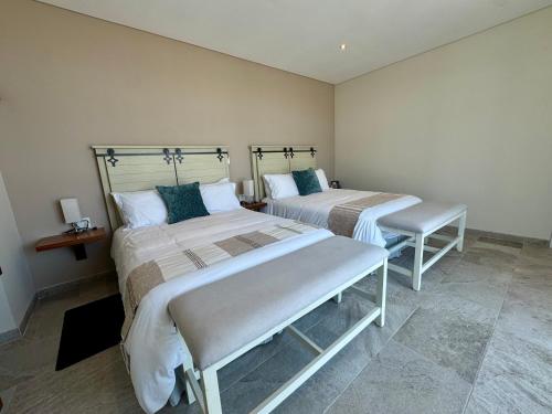 two beds in a room with sidx sidx sidx sidx sidx at Suites Lassa in Ensenada