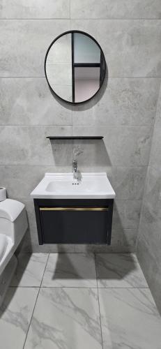 a bathroom with a sink and a mirror on the wall at CLUB 33 FIT Hotel Gym in Huancayo