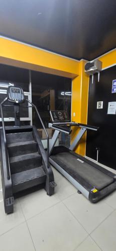 a staircase in a gym with a treadmill and a stair case at CLUB 33 FIT Hotel Gym in Huancayo