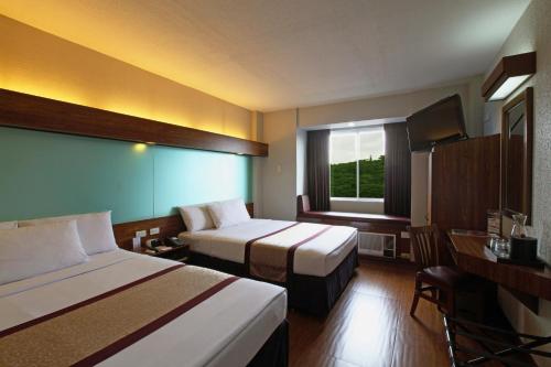 Postel nebo postele na pokoji v ubytování Microtel by Wyndham Baguio