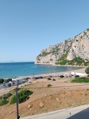 a beach next to the ocean with a mountain at Appartement Wad Marsa in Taoutiet el Bioute
