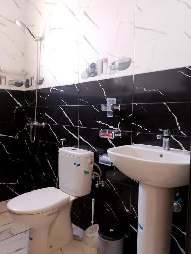 a black and white bathroom with a toilet and sink at Appartement Wad Marsa in Taoutiet el Bioute
