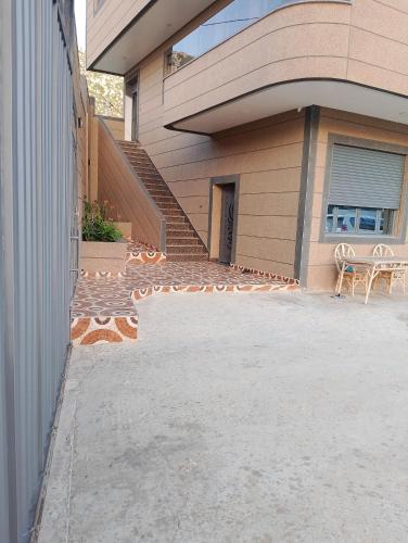 a house with a patio and stairs in front of it at Appartement Wad Marsa in Taoutiet el Bioute